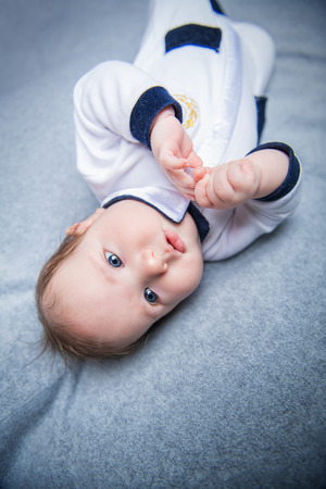 A portrait of a beautiful baby in the bed. Family, parenthood. Goods for newborns.の写真素材