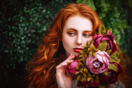 A close up portrait of a lovely mysterious girl with roses. Beauty, cosmetics.の写真素材