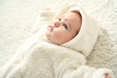 A portrait of a beautiful baby lying in the bed. Family, parenthood. Goods for newborns.
