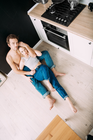 Two young people in love are together in the kitchen. Love affair, jeans.の写真素材
