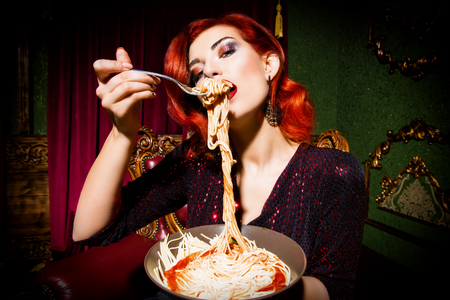 A close up portrait of a beautiful woman posing in the vintage interior and having a meal. Beauty, fashion, interior.の写真素材