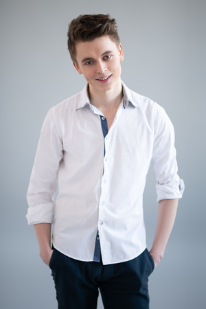 A close up portrait of a young guy in a shirt posing indoor. Fashion and beauty for men.の写真素材