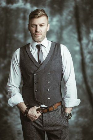 A portrait of a handsome brutal mature man posing in the studio. Casual formal fashion, men's beauty.の写真素材