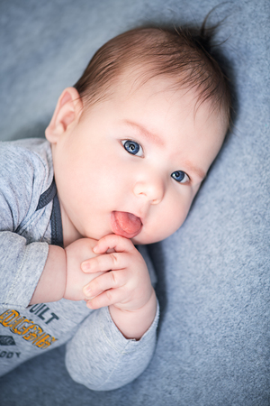 A portrait of a beautiful baby in the bed. Family, parenthood. Goods for newborns.の写真素材