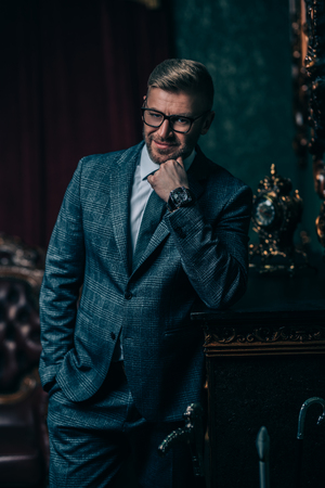 A portrait of a handsome smiling mature man posing in the studio over the black background. Casual formal fashion, men's beauty.の写真素材