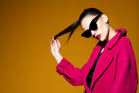 A portrait of a fashionable young lady posing in the studio. Style, beauty, spring fashion.の写真素材
