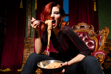 A close up portrait of a beautiful woman posing in the vintage interior and having a meal. Beauty, fashion, interior.の写真素材