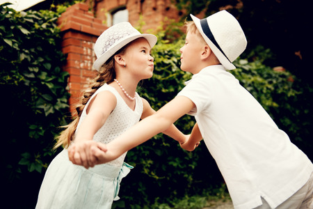 Walking kids in a garden. Looking back. Warm summer weather.の写真素材