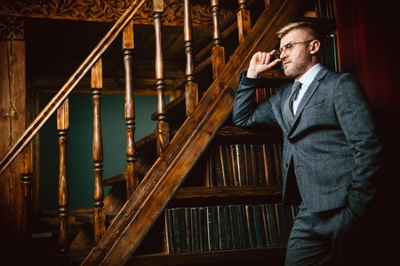 A portrait of a handsome mature man in a formal costume reading a book. Men's beauty, fashion.の写真素材
