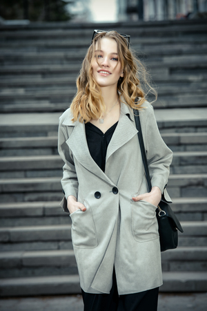 Modern young woman standing on a city street. Beauty, city fashion.の写真素材