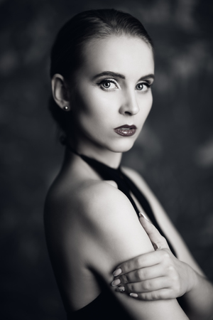 A portrait of a young lady posing over the grunge background in the studio. Style, beauty, fashion.の写真素材