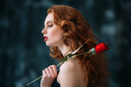 A portrait of a lovely mysterious girl with a red rose. Beauty, cosmetics.の写真素材