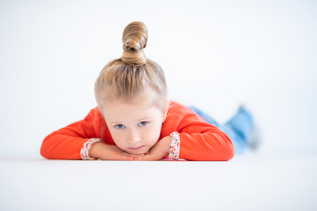 A portrait of a pretty child girl posing in the studio over the white background. Kids, fashion, casual style, beauty.の写真素材