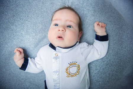 A portrait of a beautiful baby lying in the bed. Family, parenthood. Goods for newborns.