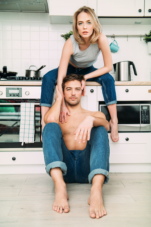Two young people in love are together in the kitchen. Love affair, jeans.の写真素材