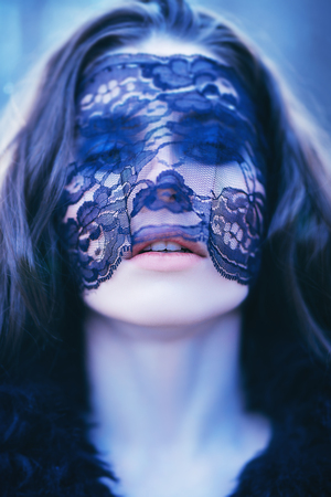 A portrait of a beautiful mysterious girl in black clothes and a mask posing in the forest. Beauty, nature.の写真素材