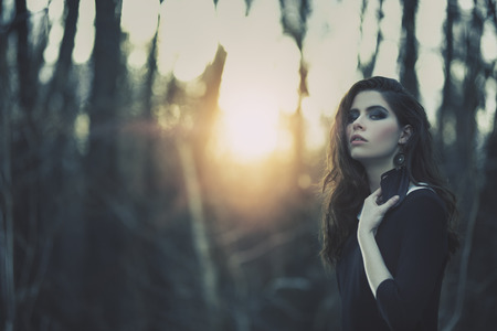 A portrait of a beautiful mysterious girl in black walking in the forest. Beauty, nature.の写真素材