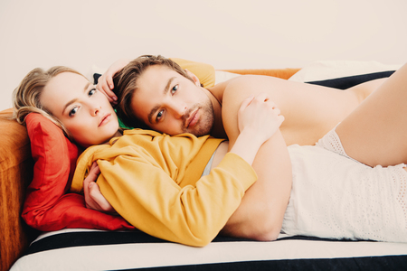 Two young people in love are together on the sofa. Love affair, beauty, fashion.の写真素材