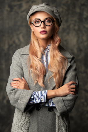 A portrait of a fashionable bright lady posing in studio over grunge background. Fashion for women.の写真素材