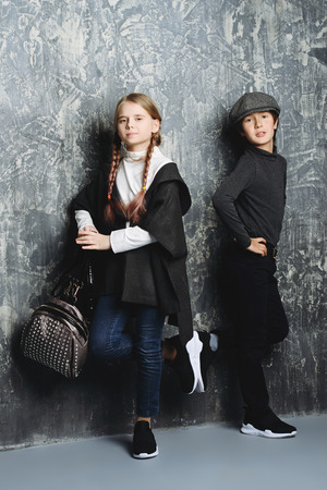 Kid's fashion. Two modern children posing together at studio. Clothes for children.の写真素材