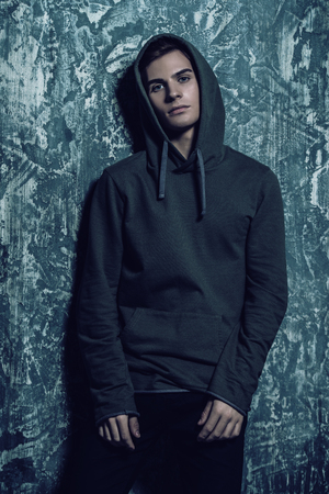 Portrait of a teenage boy over grunge background. Studio shot. Teen fashion.の写真素材