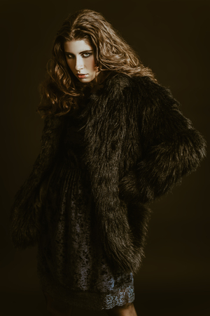 A portrait of a beautiful gorgeous girl in black posing in the studio over the black background. Beauty, fashion.の写真素材
