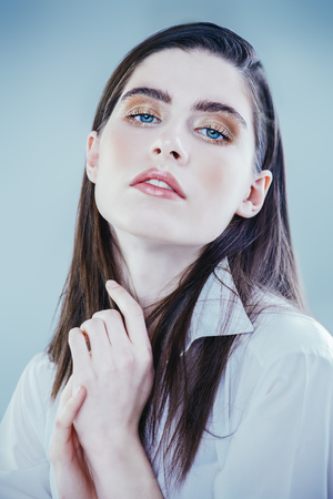 A close up portrait of a beautiful dark-haired young woman posing over the white background. Beauty, cosmetics.の写真素材