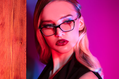 A close up portrait of a confident lady wearing glasses. Beauty, make-up, style.
