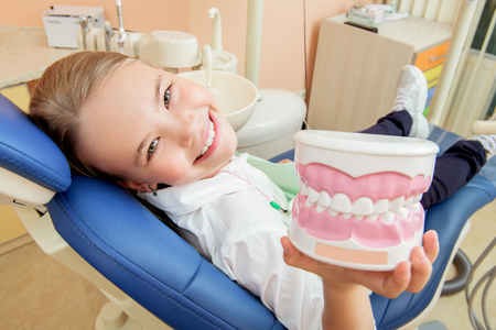 A portrait of a child girl in the cabinet of a dentist. Treatmeat, medicine, hospital.の写真素材