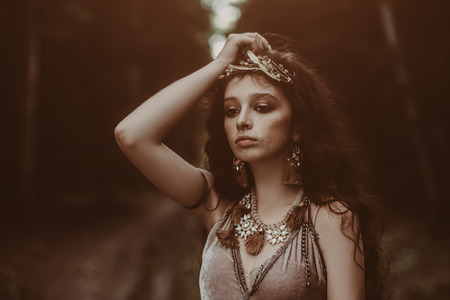 Close-up portrait of a enigmatic beautiful girl posing in a forest. Beauty, fashion. Cosmetics and makeup.の写真素材
