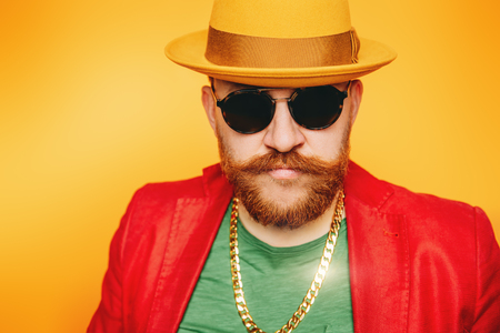 A portrait of a bright man posing in the studio over the yellow background. Men, beauty, optics, colors, fashion.の写真素材