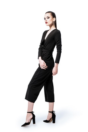 A full length portrait of a fashionable young lady posing in the studio over the white background. Style, formal fashion.の写真素材