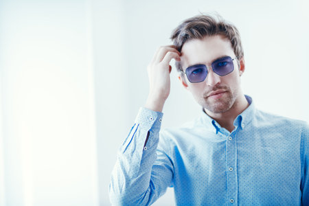 A portrait of a handsome man in sunglasses over the white background. Beauty, fashion for men.の写真素材