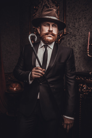 A portrait of an adult man with an umbrella posing in the interior. Men's beauty, fashion, style.の写真素材