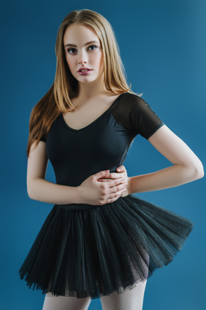 A portrait of a young pretty woman posing in the studio over the blue background. Fashion for ballet dancers, beauty.の写真素材