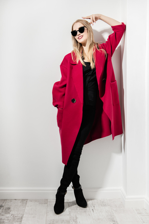 A full length portrait of a fashionable young lady posing in the studio over the white background. Beauty, fashion, style.の写真素材