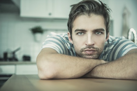 A close up portrait of a handsome dreamy man. Home, casual fashion.の写真素材