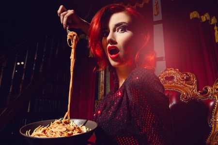 A close up portrait of a beautiful woman posing in the vintage interior and having a meal. Beauty, fashion, interior.の写真素材