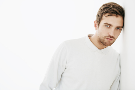 A portrait of a handsome man in white over the white background. Beauty, fashion for men.の写真素材