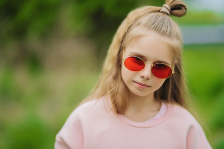 A close up portrait of a beautiful teenager girl posing in the field. Kids, nature, summer casual fashion, beauty.の写真素材