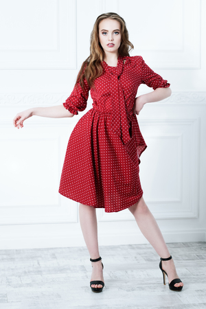 A full length portrait of a young fashionable woman posing in the studio over the white background. Summer casual fashion.の写真素材