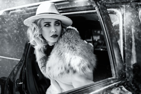 A portrait of a gorgeous blonde lady posing in a car. Car, fashion, beauty, chick.の写真素材