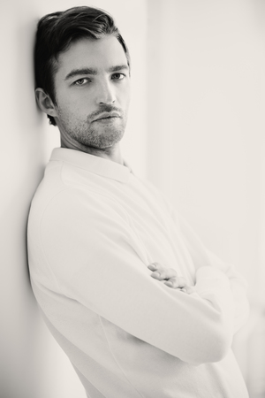 A portrait of a handsome man in white over the white background. Beauty, fashion for men.の写真素材