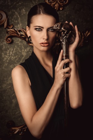A portrait of a beautiful young dark-haired woman posing in the room. Beauty, cosmetics, fashion, interior.の写真素材