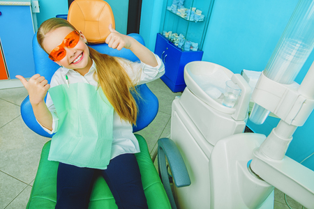 A portrait of a child girl in the cabinet of a dentist. treatment, medicine, hospital.の写真素材
