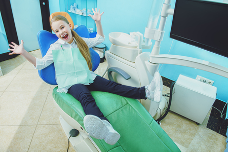 A portrait of a child girl in the cabinet of a dentist. treatment, medicine, hospital.の写真素材