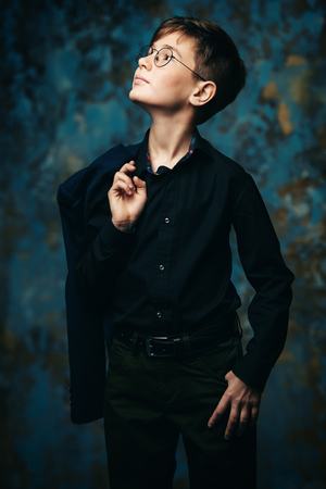 A portrait of a boy wearing classic clothes and glasses. Beauty, fashion, teenagers.の写真素材