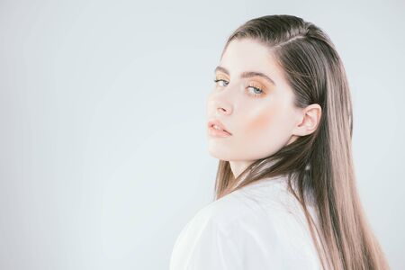 A close up portrait of a beautiful dark-haired young woman posing over the white background. Beauty, cosmetics.の写真素材