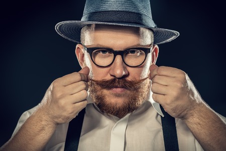 A close up portrait of a thoughtful man posing in the studio over the black background. Men's beauty, fashion, style.の写真素材