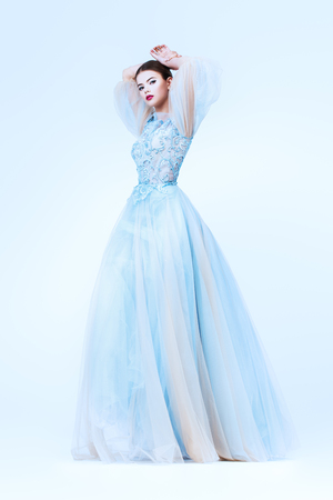 A full length portrait of a charming lady in a wedding dress posing in the studio. Wedding fashion, bride.の写真素材